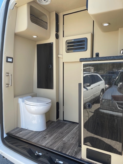 with tinted windows and a roof antenna.|White Mercedes-Benz Sprinter conversion van for rv rental — photo 2