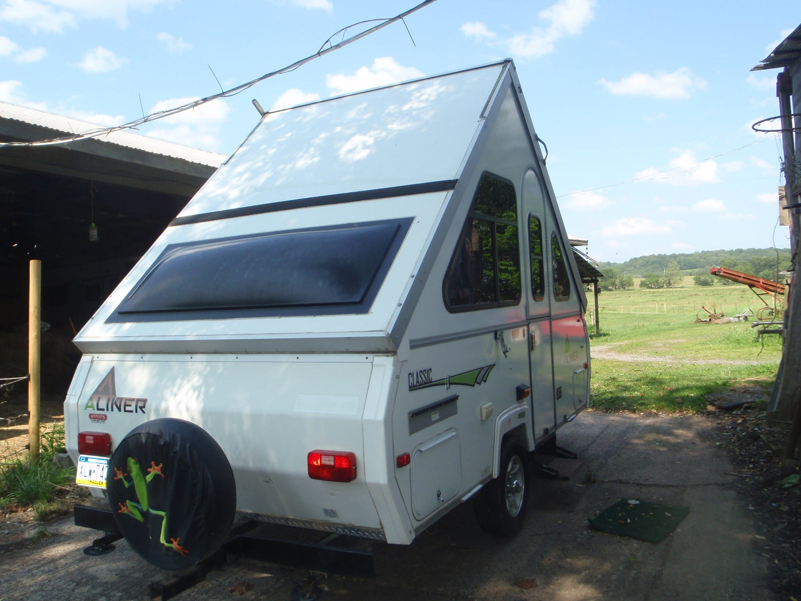 White A-liner A-frame pop-up camper with frog spare tire cover