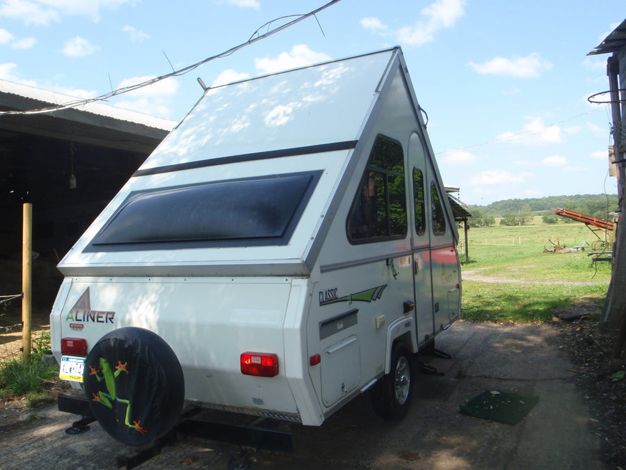 White A-liner A-frame pop-up camper with frog spare tire cover