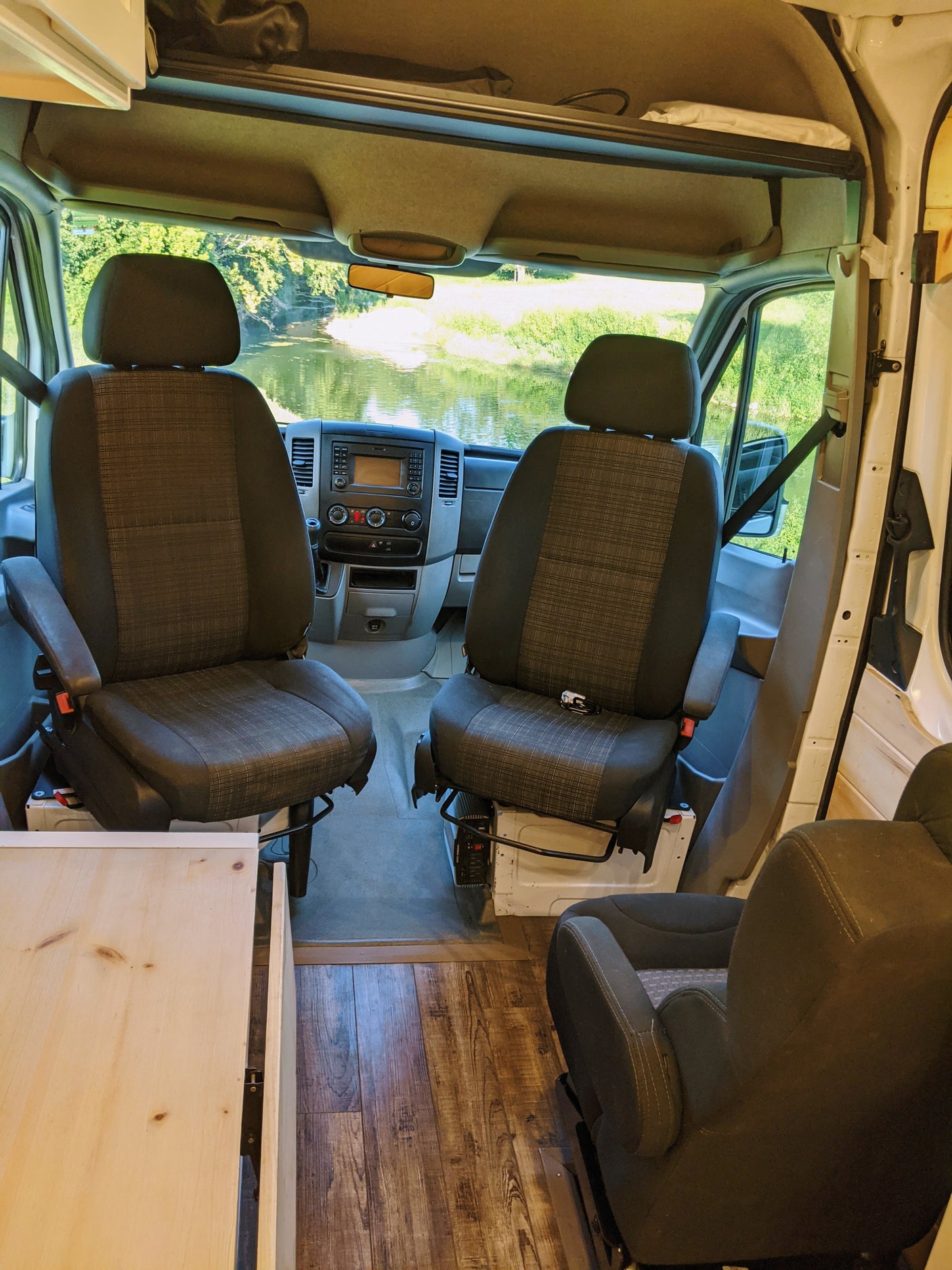 Spacious camper van interior, perfect for an RV rental adventure with front captain's chairs and scenic views.