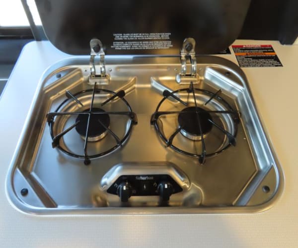 featuring a handheld sprayer and dual faucet controls.|RV rental's compact kitchen boasts a sink