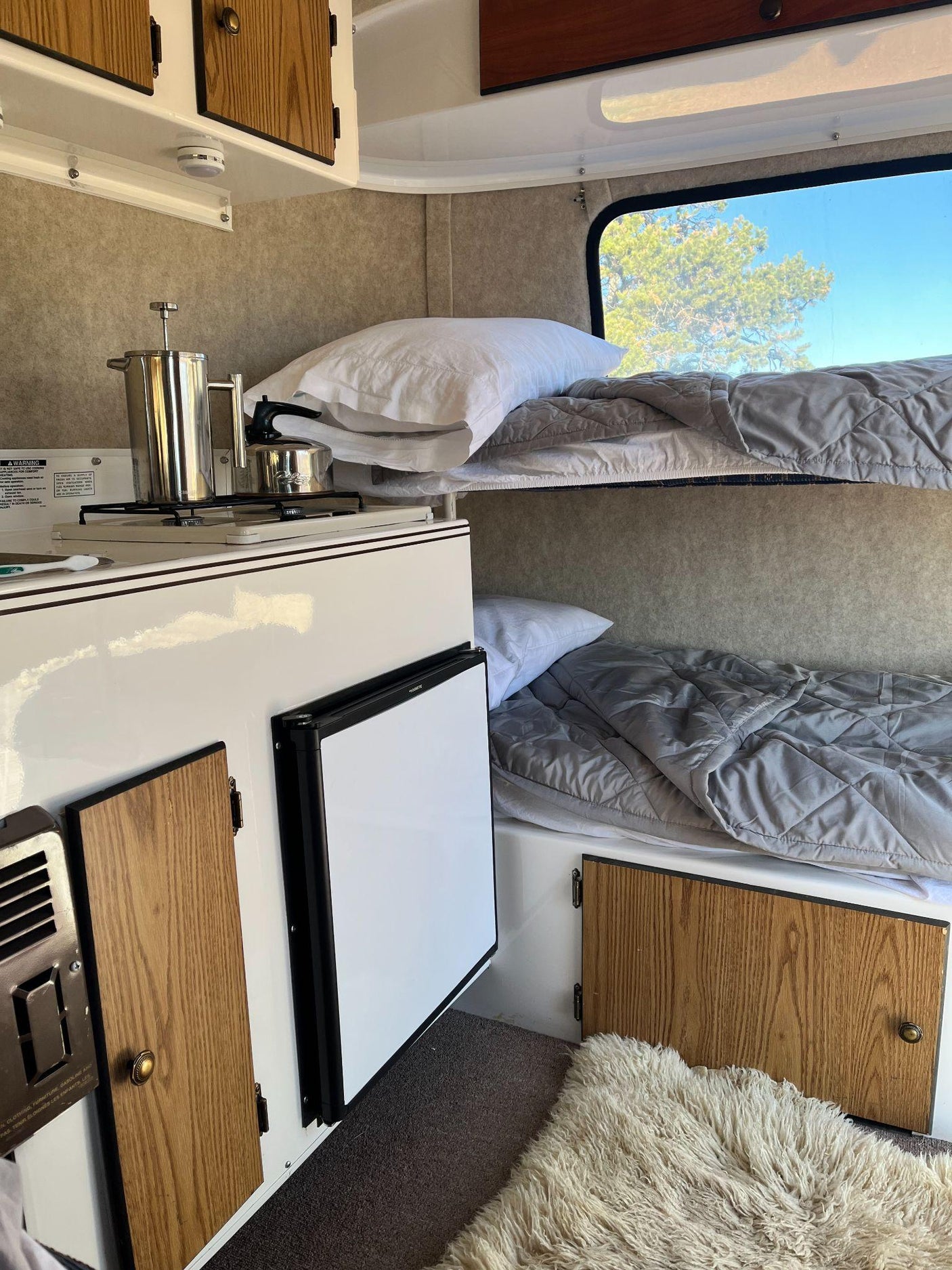 Compact RV rental interior featuring bunk beds