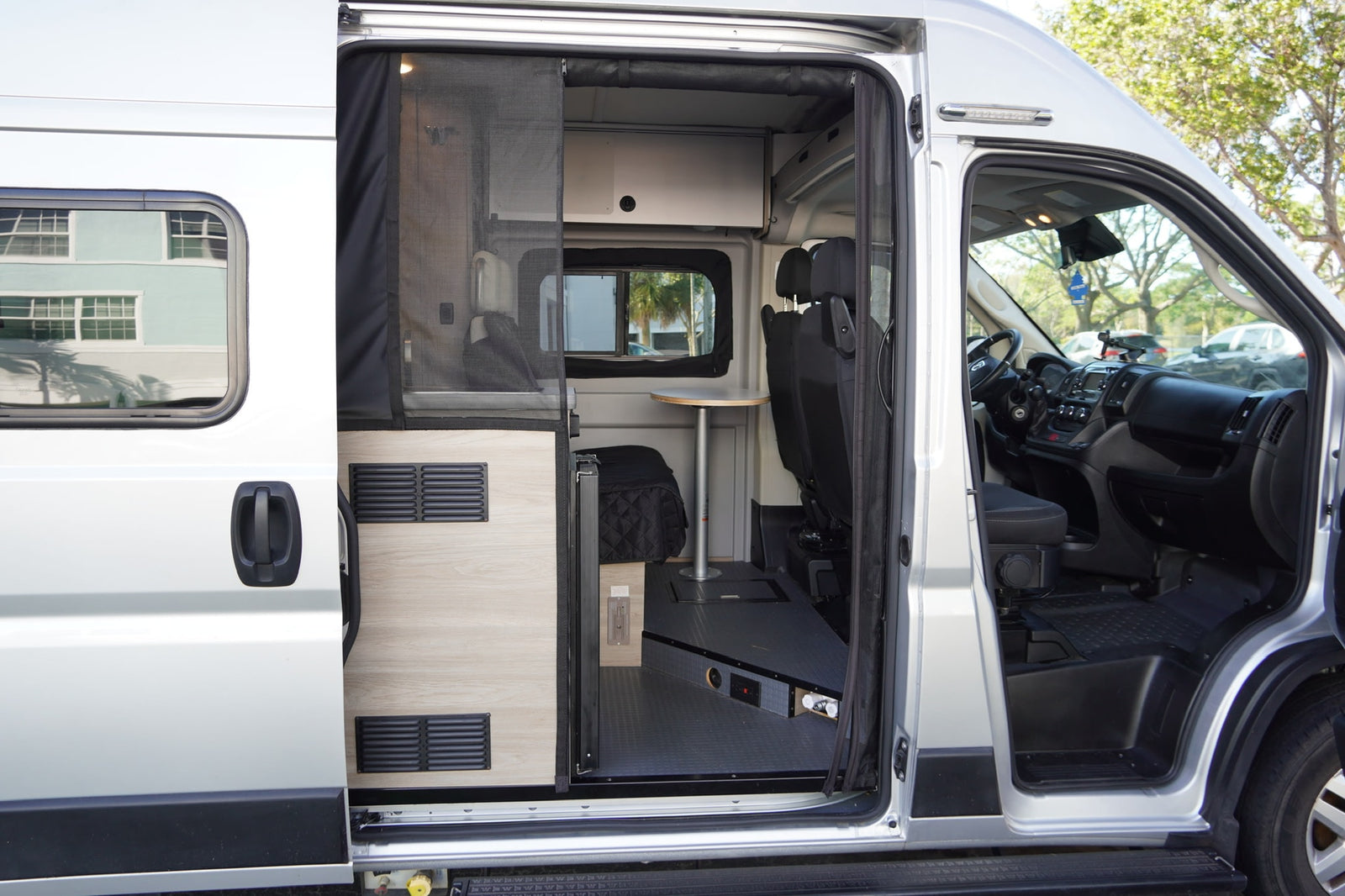 showcasing its custom conversion features and compact living space.|This RV rental interior features a compact kitchenette with sink & stovetop