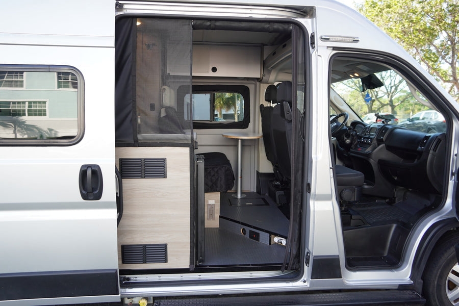 showcasing its custom conversion features and compact living space.|This RV rental interior features a compact kitchenette with sink & stovetop