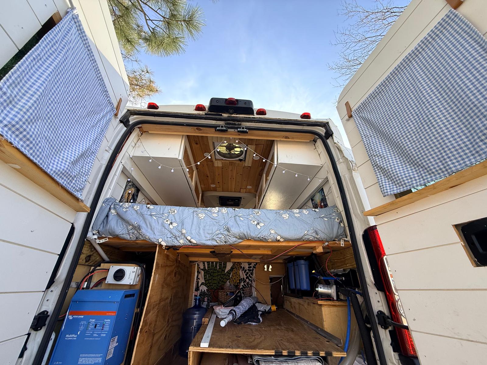 Explore this custom RV rental's clever interior: cozy bed, Victron power, and water filtration for off-grid van life.