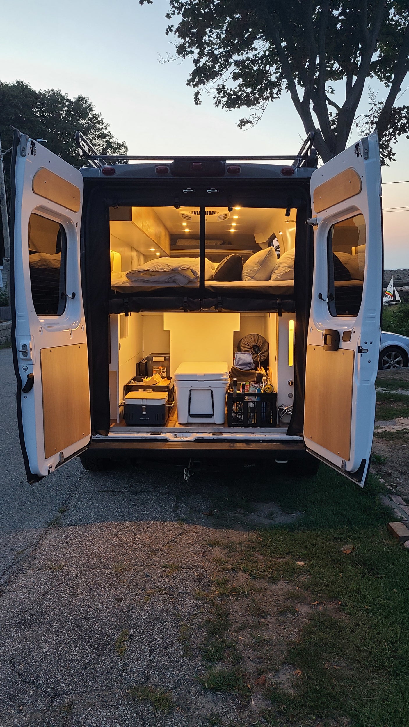 Our RV rental campervan offers illuminated comfort: upper bed, lower storage, perfect for van life adventures.