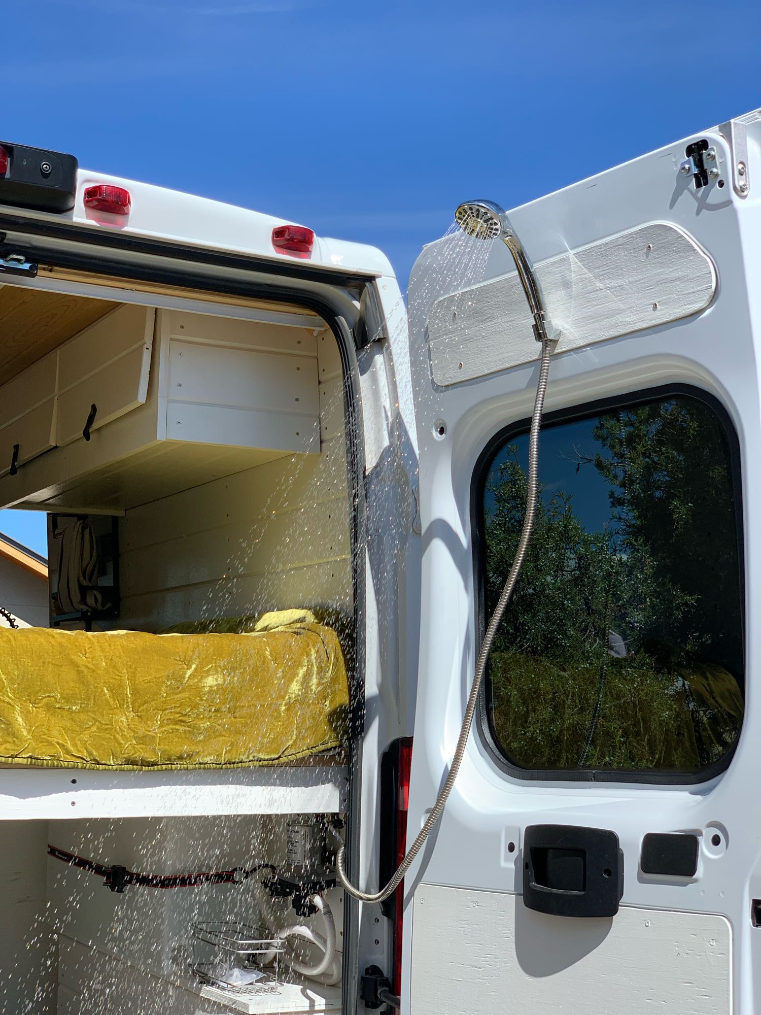 Experience mobile living convenience! This RV rental features an outdoor shower from its rear doors, perfect for van life.