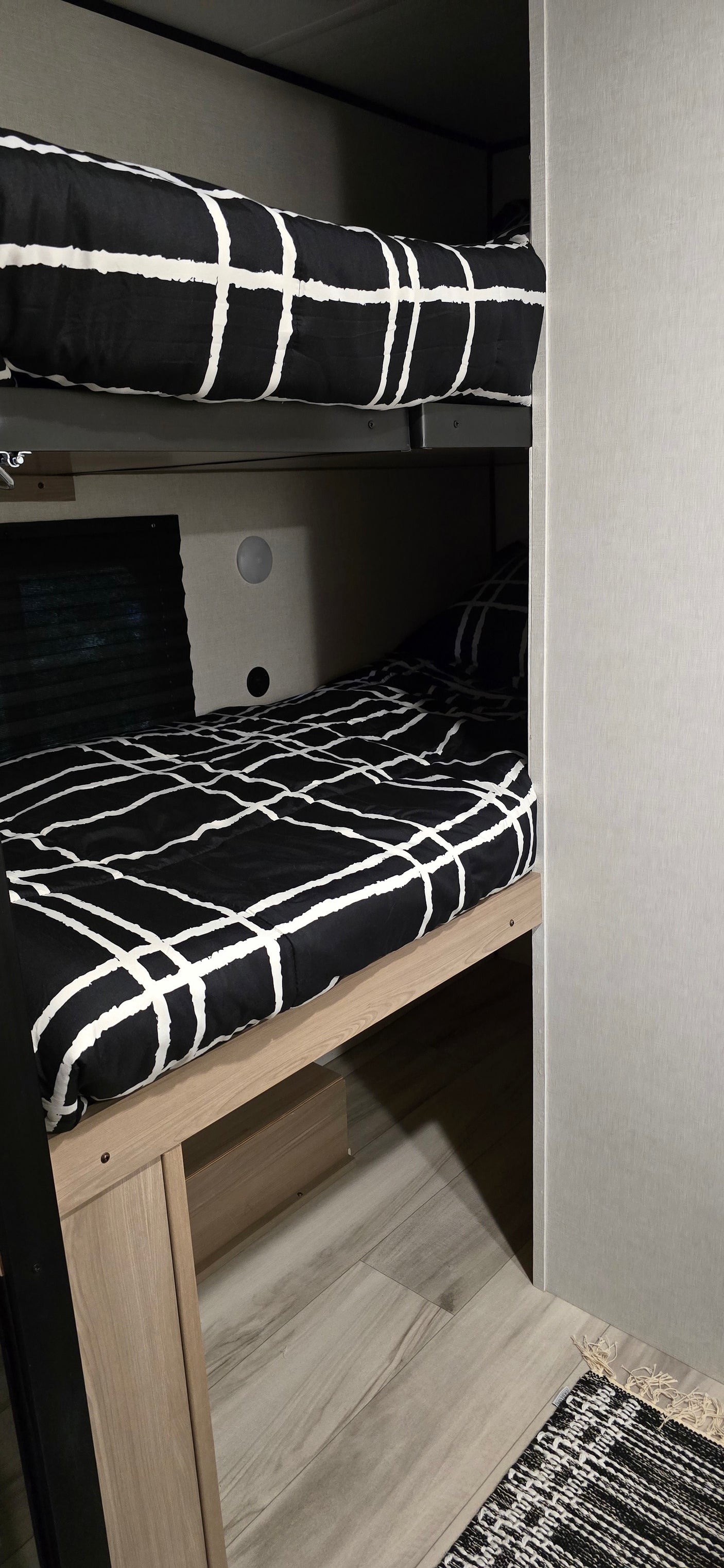 Modern black and white bunk beds inside a cozy RV rental, perfect for family adventures.