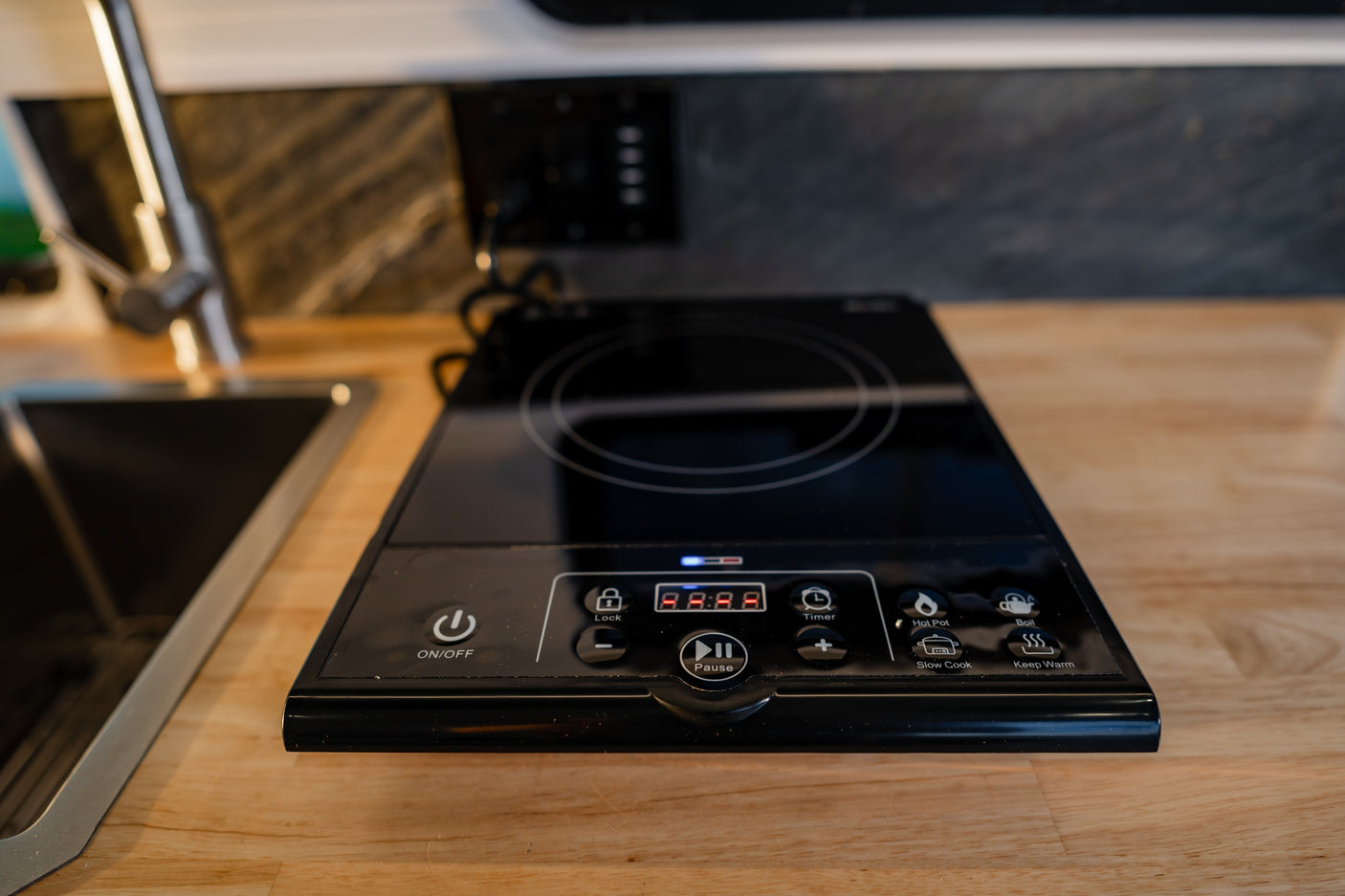 This RV rental kitchen features a portable induction cooktop with digital controls for cooking modes like boil & hot pot.