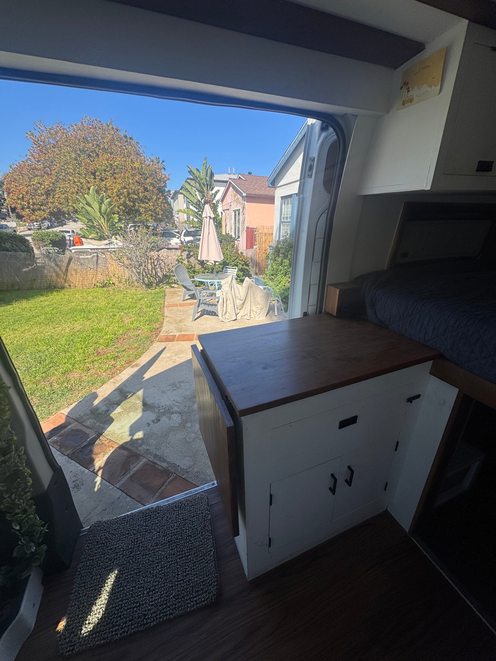 Inside a comfy RV rental, gazing out at a charming backyard and sunny patio. Your next road trip awaits!