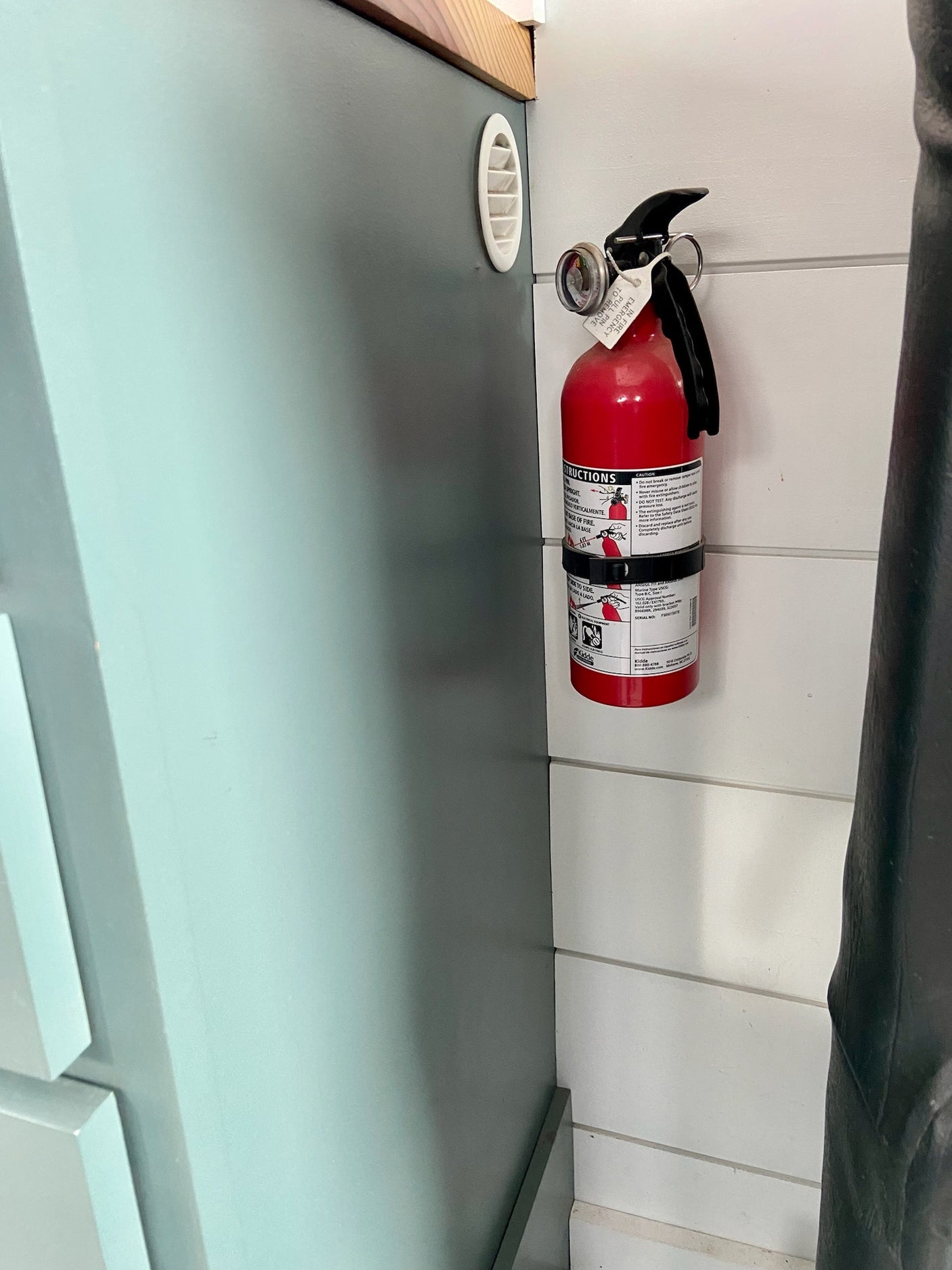 Essential safety for your RV rental journey: a red fire extinguisher mounted in the vehicle, ready for emergencies.
