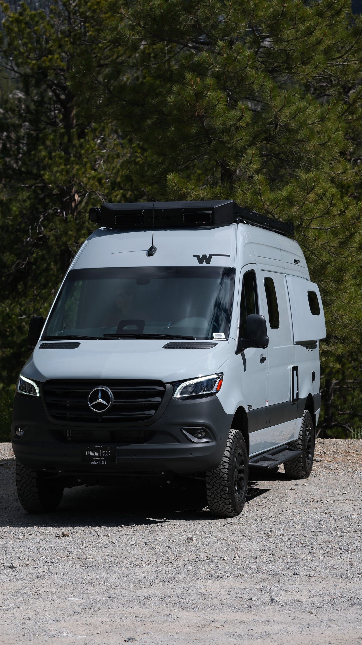 Light grey Mercedes-Benz Sprinter camper van with off-road tires, perfect for an RV rental nature escape.