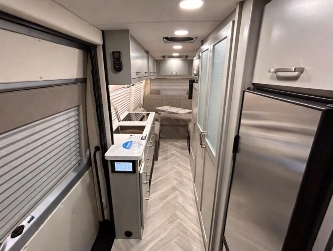parked at night under bright lights. Great for an rv rental adventure or road trip.|Experience this modern Class B RV rental's cockpit. Features include a sleek dashboard