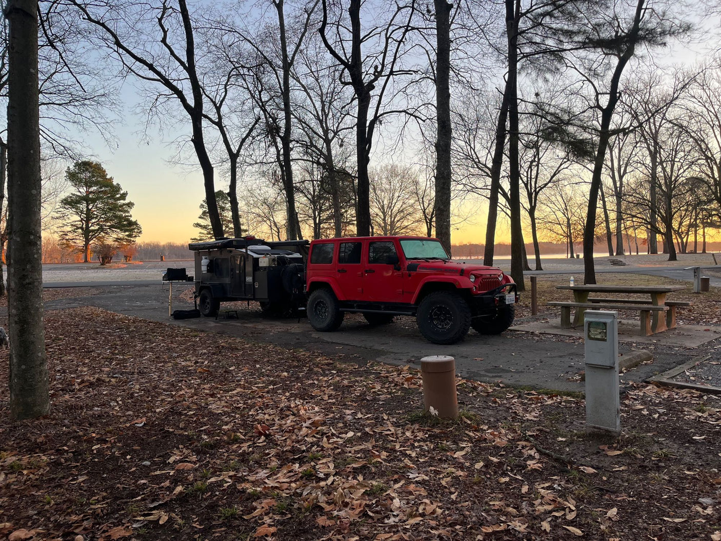 sunlit landscape.|Camping with an RV rental at sunset. A black camper