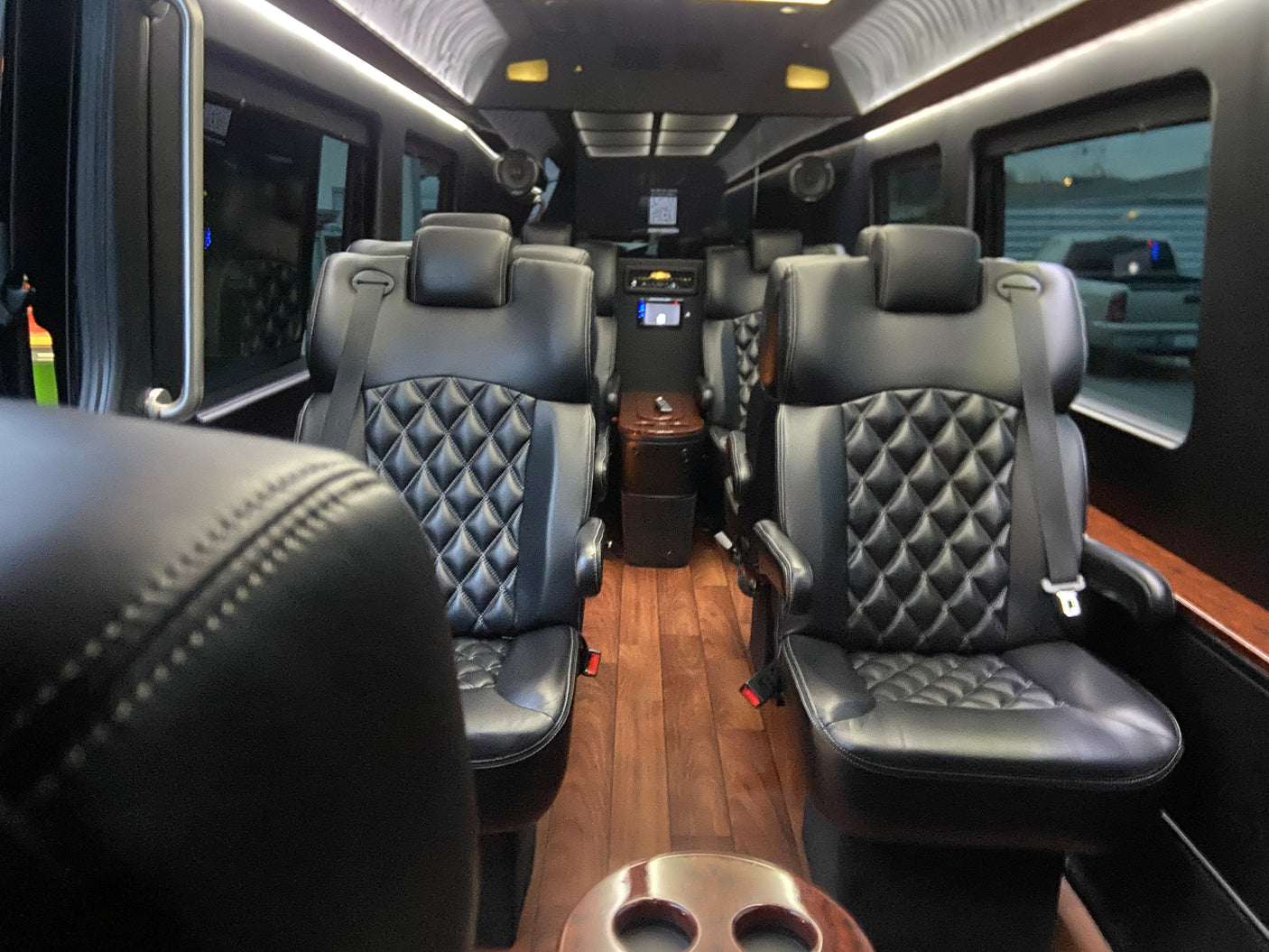 Plush RV rental interior showcasing diamond-quilted leather seating, wooden floors, and mood lighting for luxury travel.