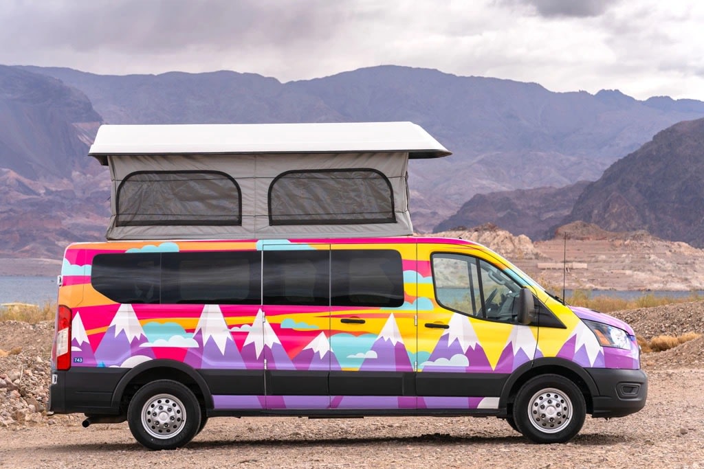 Colorful pop-top camper van RV rental with mountain mural