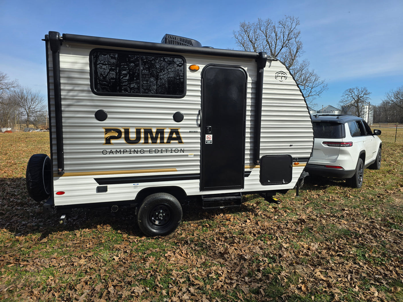 A white SUV tows a Puma Camping Edition RV, perfect for your next rv rental adventure.