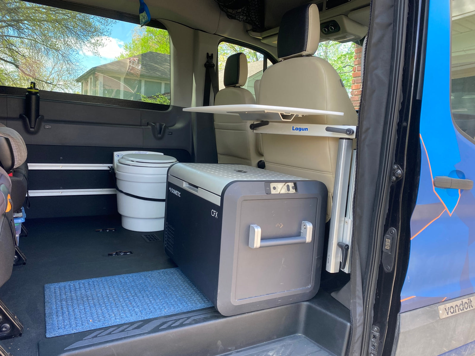 RV rental 'Vandoit' van interior shows Dometic fridge, toilet, and Lagun table, ideal for adventure travel.