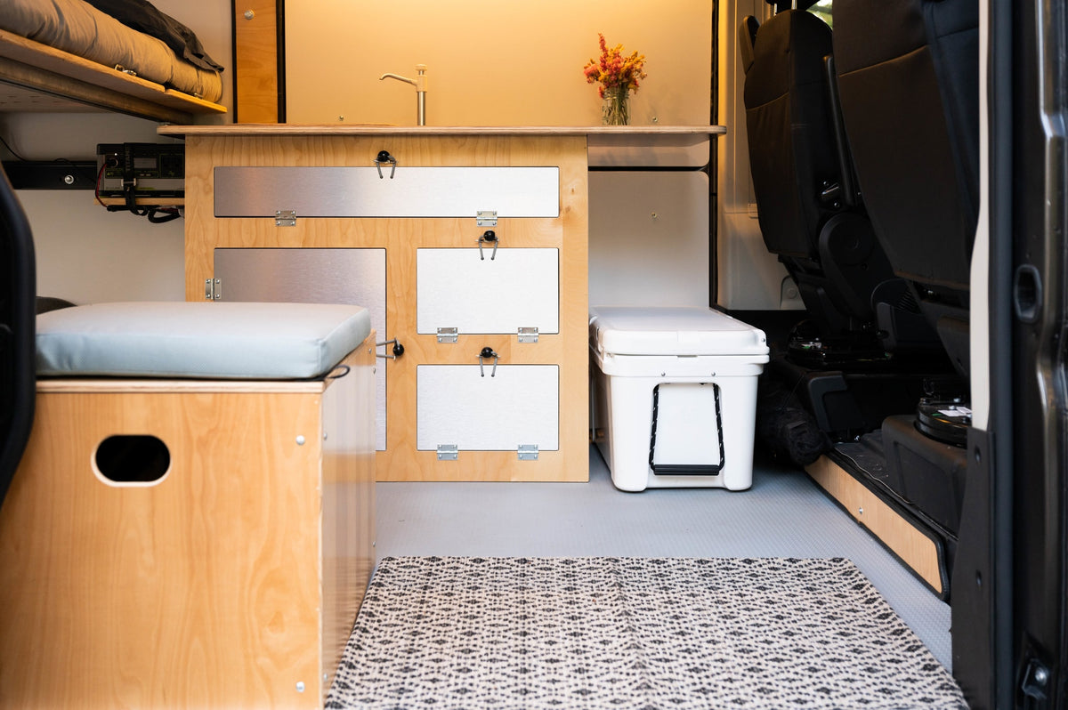 Inside an RV rental camper van: efficient kitchen, ample storage, cooler, and seating for comfortable mobile living. — photo 11