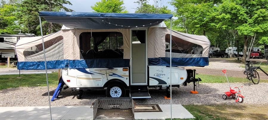 RV rental pop-up camper at a shady campground