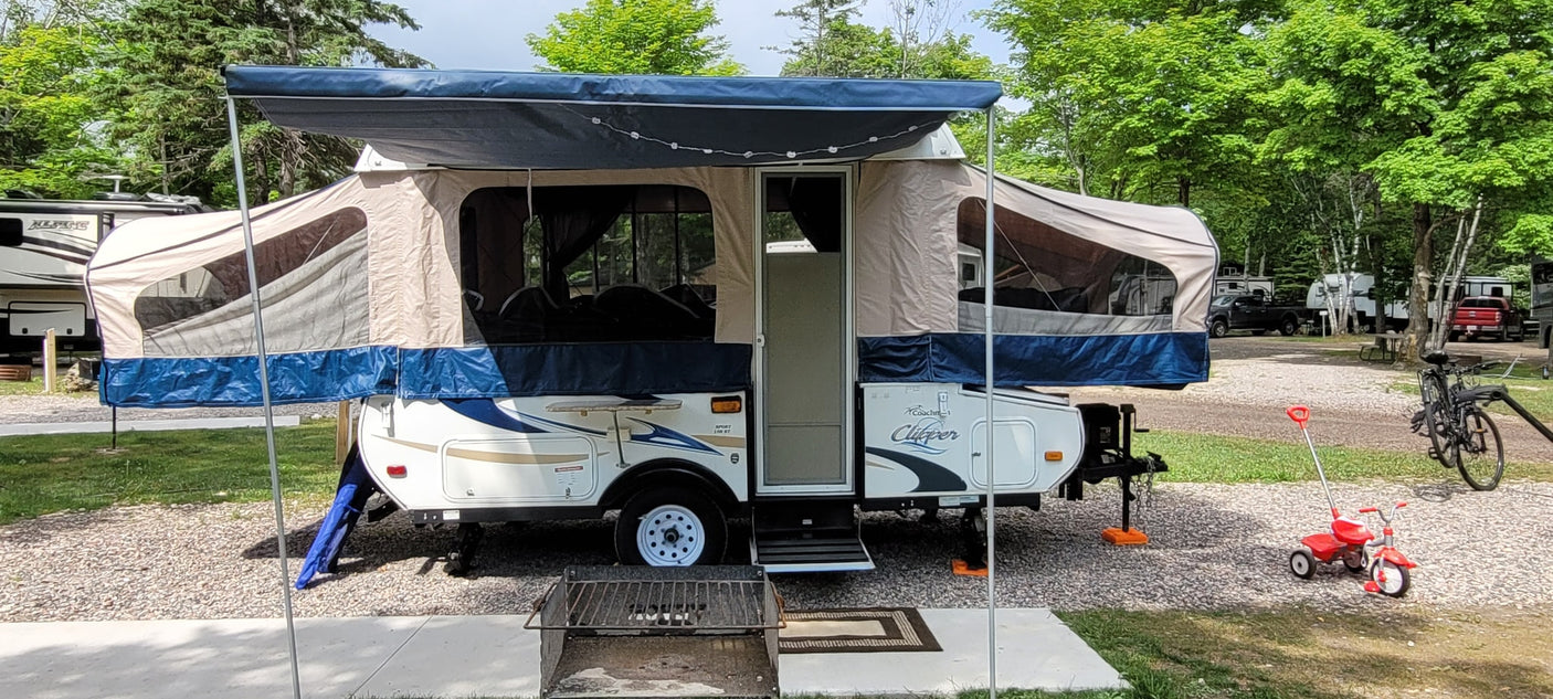 RV rental pop-up camper at a shady campground