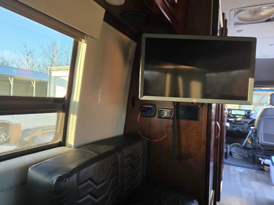 and sleek faucet.|Compact RV rental bathroom features a white toilet and integrated shower with a visible reddish stain on the floor.|RV rental: sleek