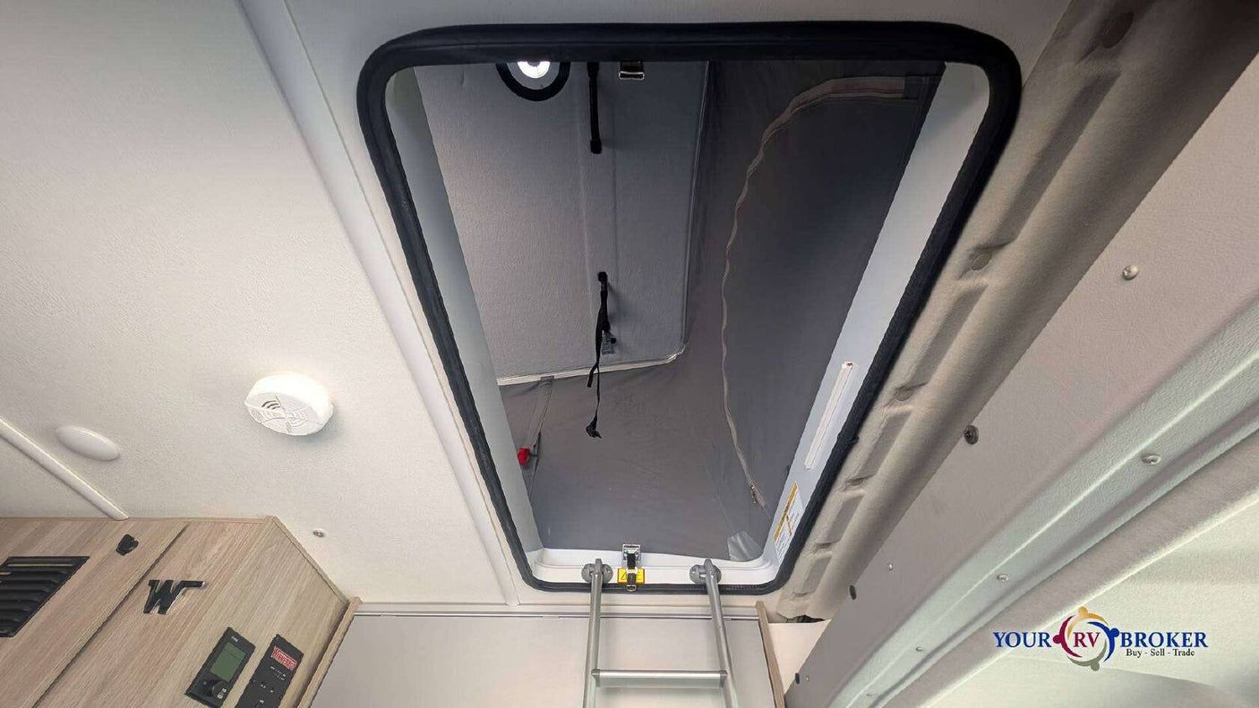 RV rental: Interior shows a ladder leading to a pop-top sleeping area. A smoke detector is visible on the ceiling.