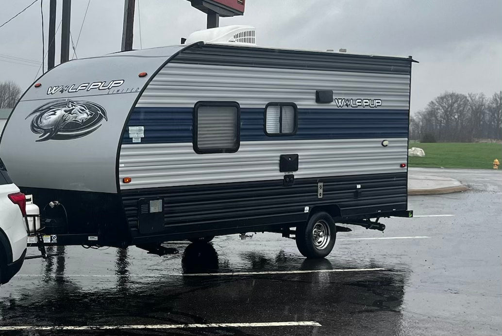 and overhead AC unit.|This RV rental interior features a cozy bedroom with a patterned bed
