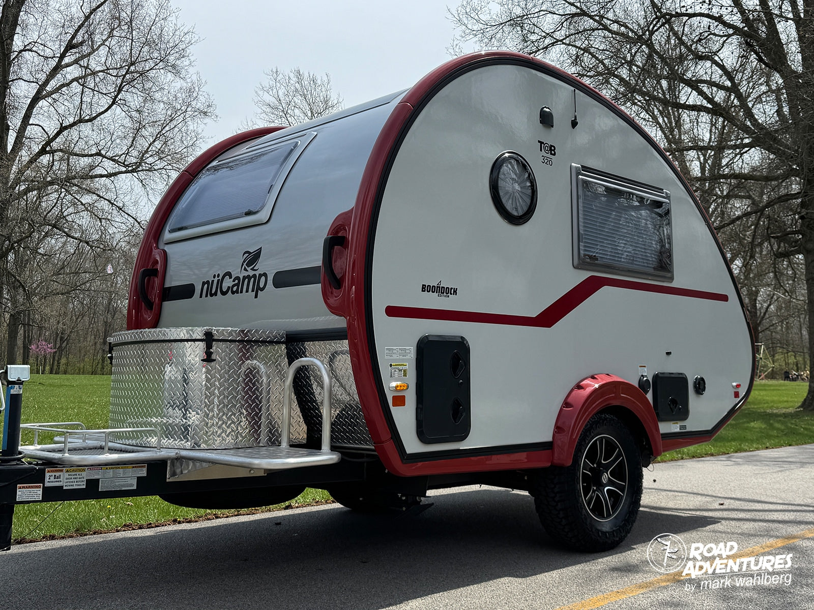 This nuCamp T@B 320 Boondock Edition teardrop camper, a perfect rv rental, is ready for adventure with its striking red and white design.