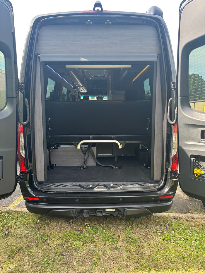 and ambient lighting for comfortable travel.|RV rental: Rear of a black camper van with open doors
