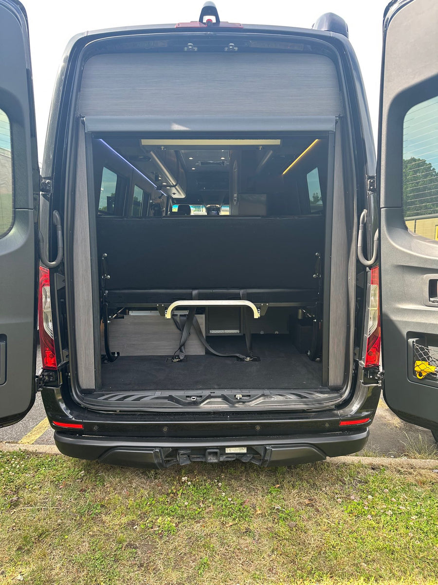 and ambient lighting for comfortable travel.|RV rental: Rear of a black camper van with open doors