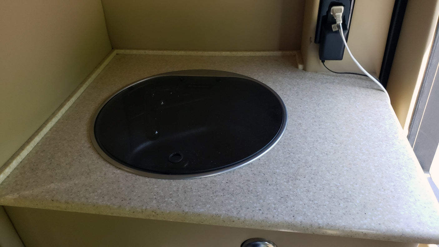 RV rental kitchenette: A compact counter with a built-in cooktop and electrical outlet for convenient mobile living.