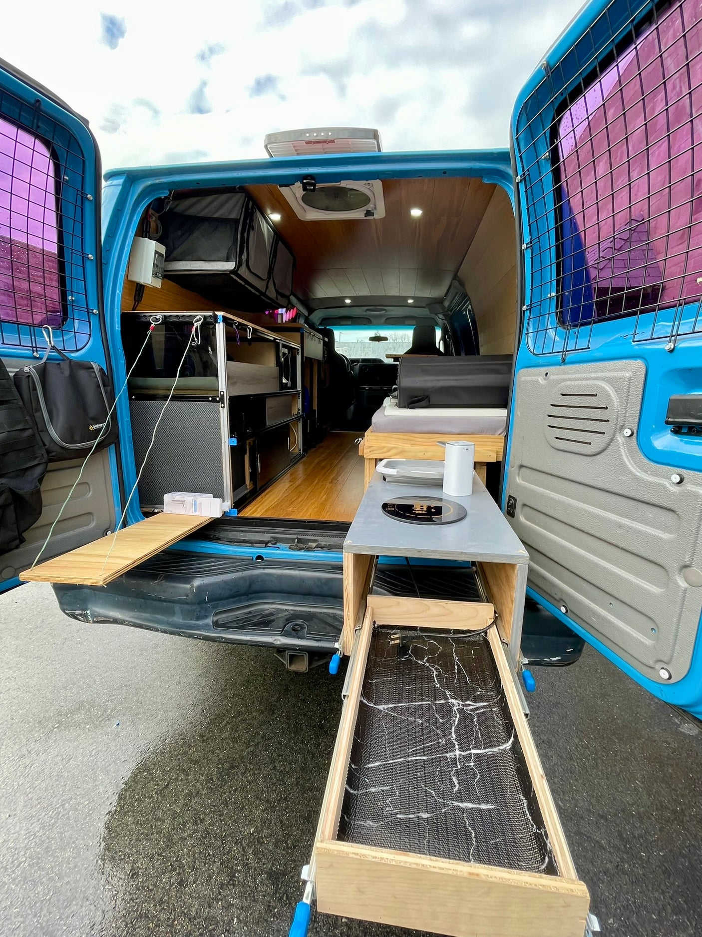 rv rental camper van conversion: Rear view reveals a functional mobile kitchen, bed, and storage for your next adventure.