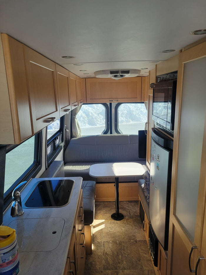 is parked at a state park amid vibrant autumn foliage.|RV rental interior: Built-in microwave