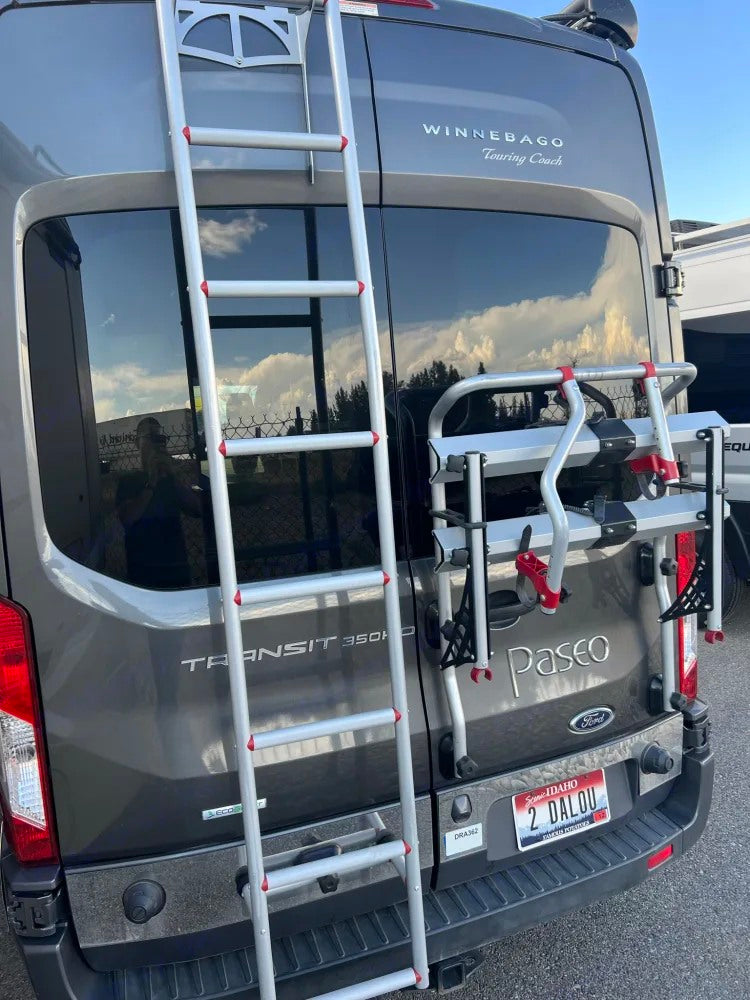 RV rental: Back of a grey Winnebago van with ladder, bike rack, and Idaho plate, ready for adventure.