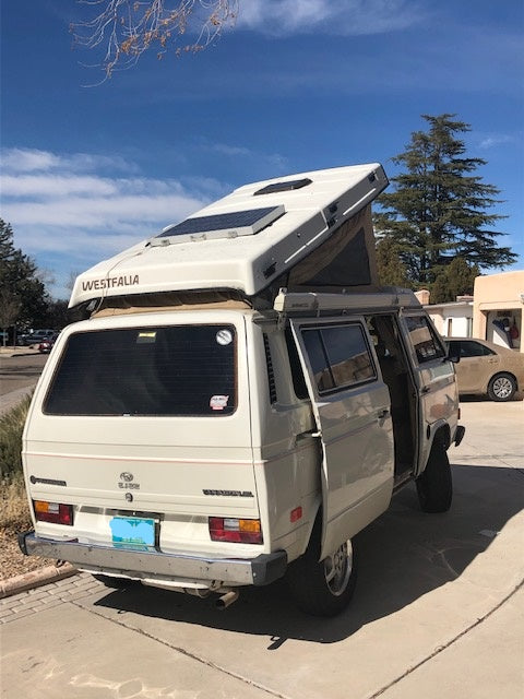 Beige VW Vanagon Westfalia pop-top camper van with solar panels. Ideal for your next rv rental and camping adventure.