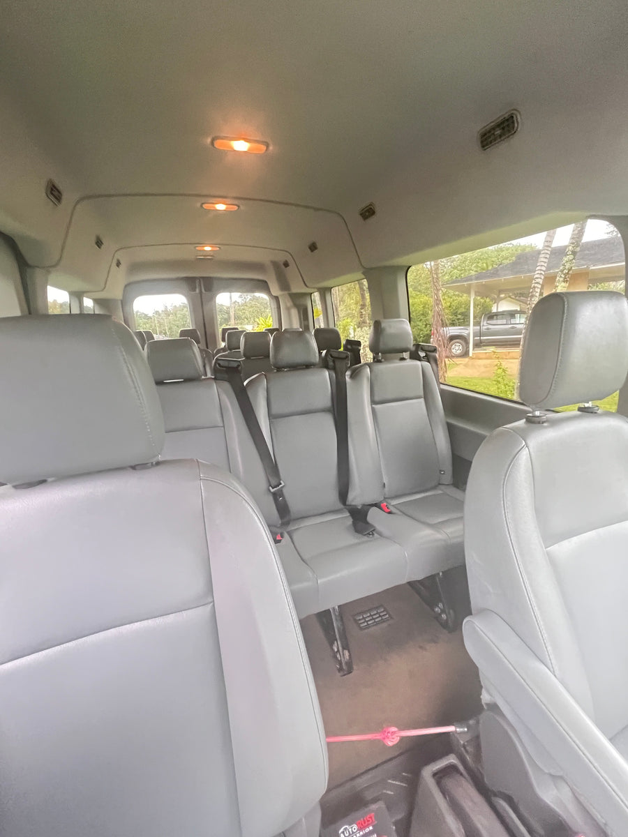 Spacious passenger van interior with gray seats & bright lights. Ideal for group trips, available through RV rental.