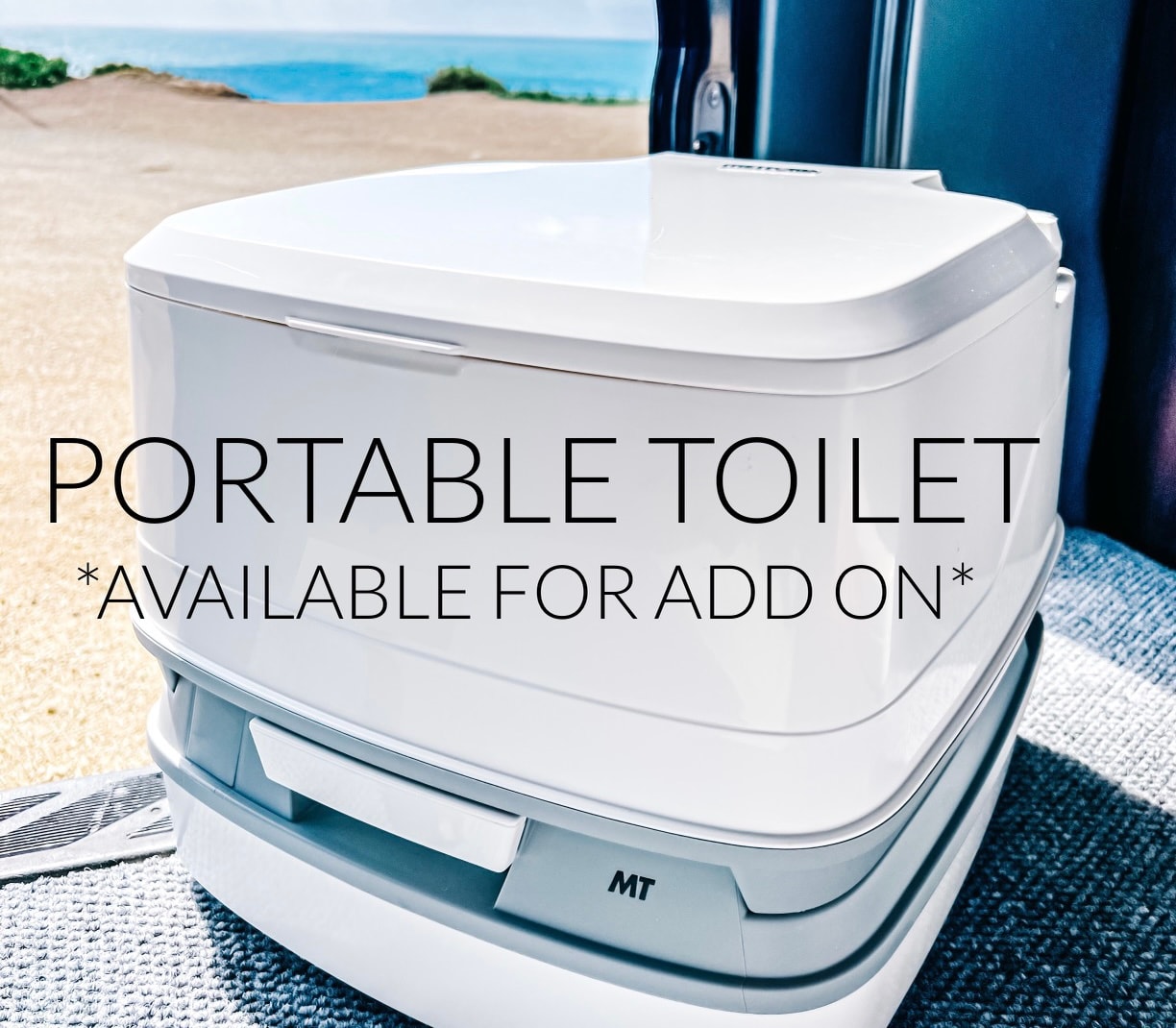 This white portable toilet, an add-on for your RV rental, offers convenience. Seen from inside a camper van overlooking a beach.