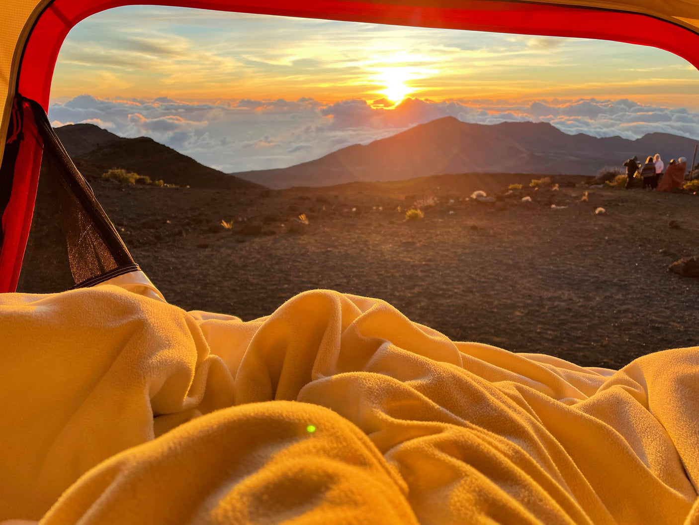 Cozy tent view of a stunning mountain sunrise with fellow campers. Ideal for an RV rental adventure!