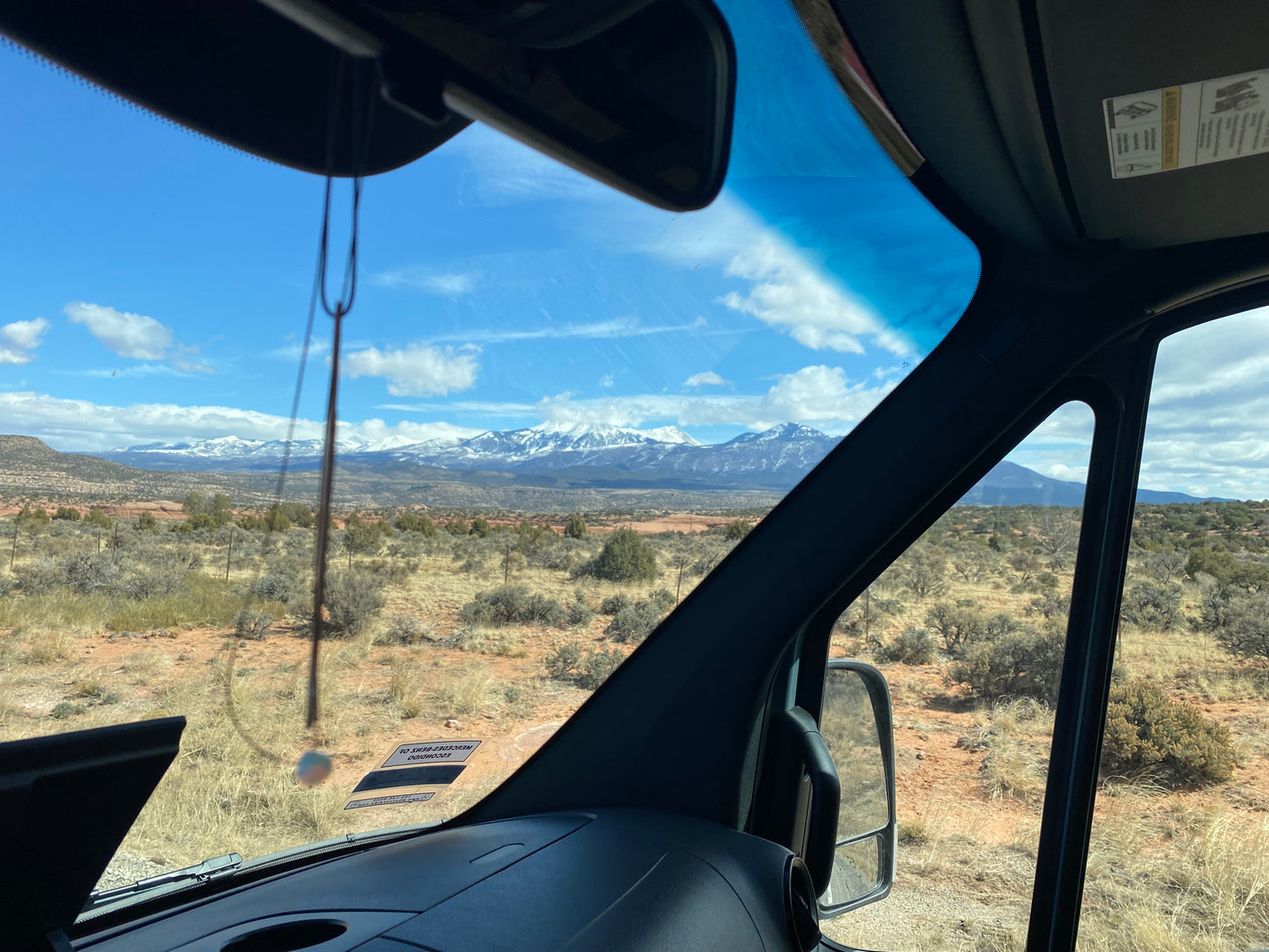 Scenic view from an RV rental, showing snow-capped mountains over a desert landscape. Perfect for a road trip adventure.