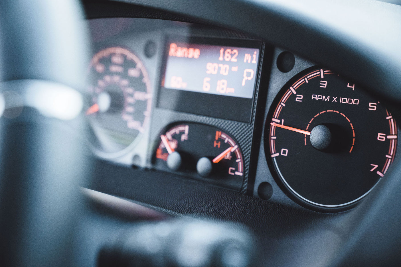 Close-up of an RV rental dashboard: digital display shows 162 miles range, 9070 miles total, and 'P' for park. Tachometer rests at zero.