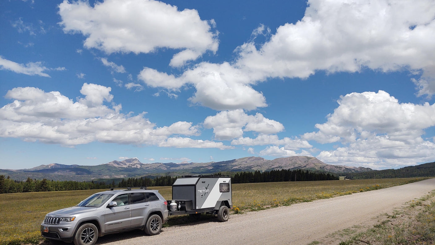 and utensils stored neatly in custom foam.|Cozy RV rental interior with bed