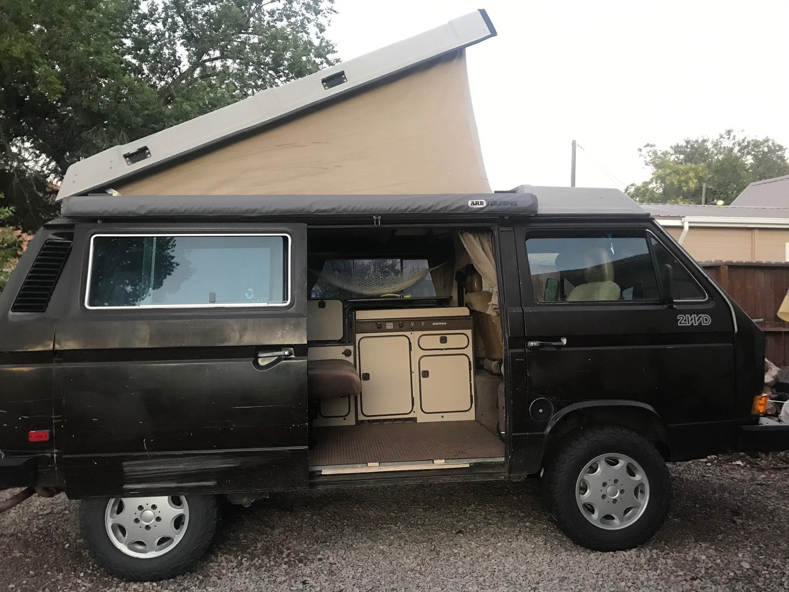 Pop-top Westfalia camper van with open door and extended roof
