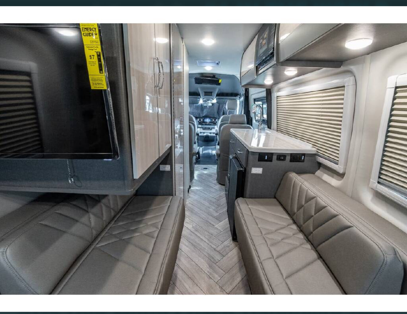 and dinette area with herringbone floor. Ready for adventure.|Modern RV rental interior with compact fridge — photo 9