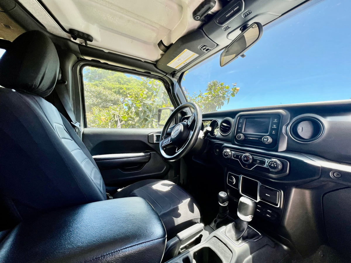 View from inside a modern Jeep. Black seats, dashboard, and a sunny outdoor scene. A rugged alternative for your next RV rental adventure. — photo 4