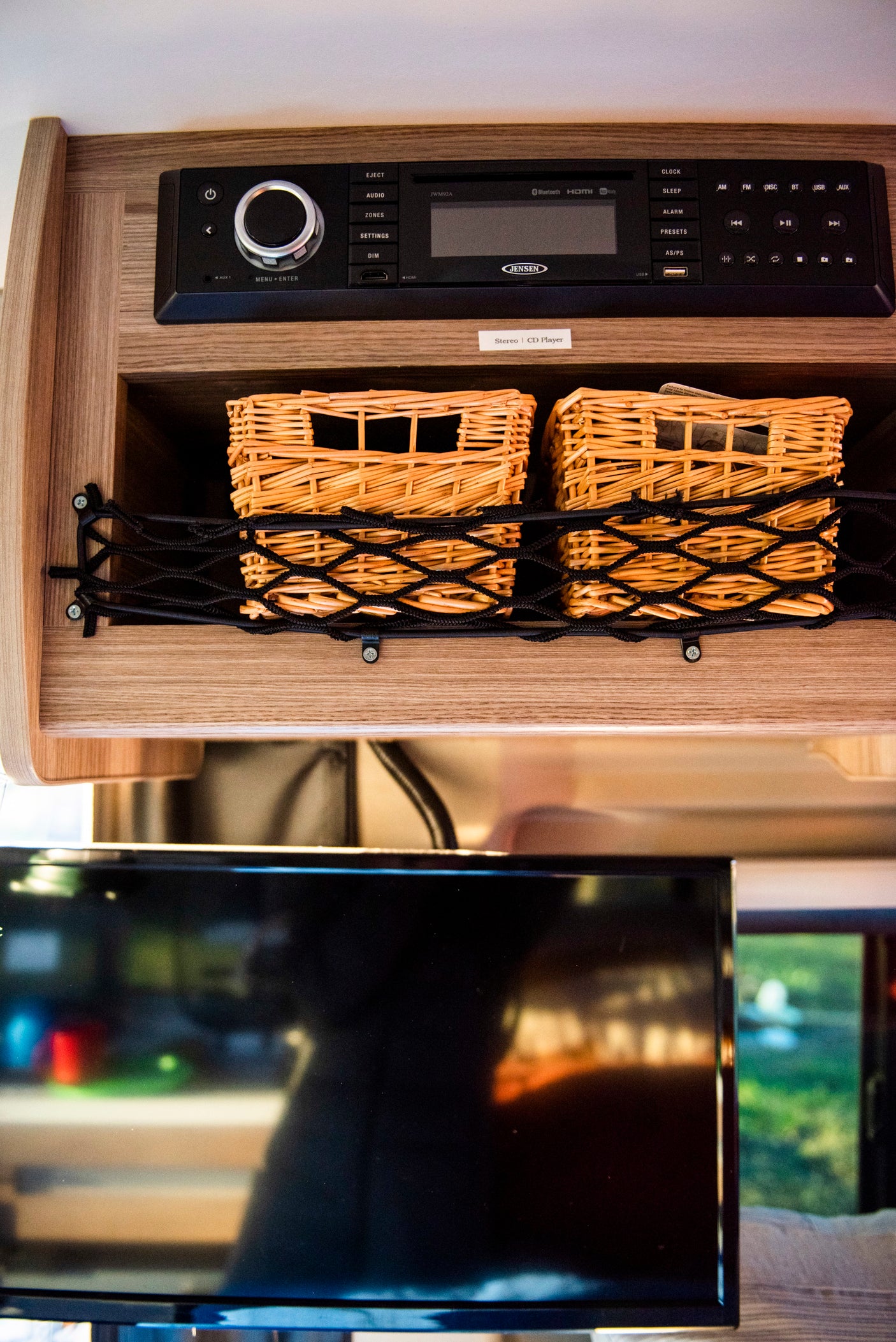 **rv rental** interior: Jensen JWM92A stereo with CD player, USB, Bluetooth; organized storage baskets & a TV.