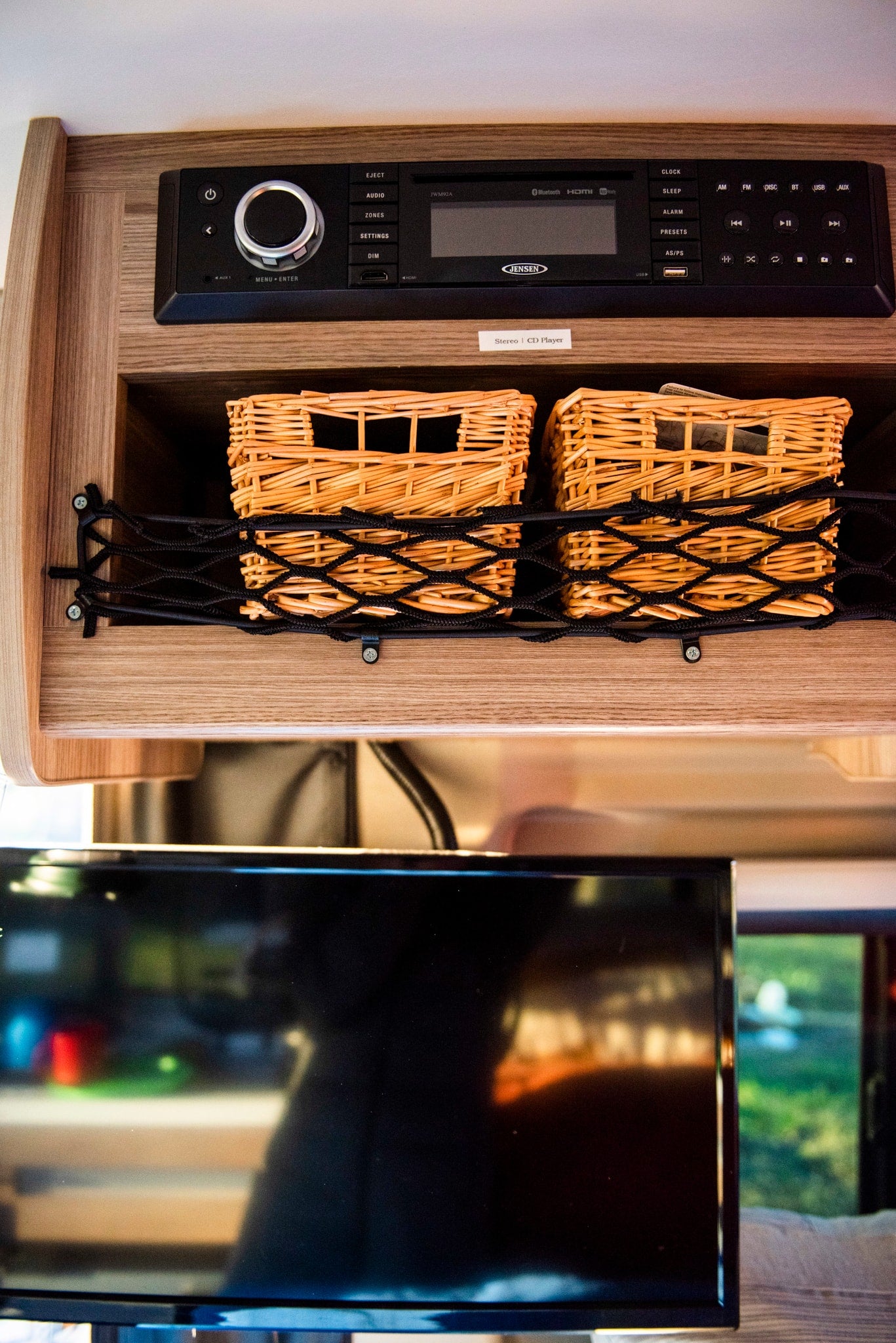**rv rental** interior: Jensen JWM92A stereo with CD player, USB, Bluetooth; organized storage baskets & a TV.