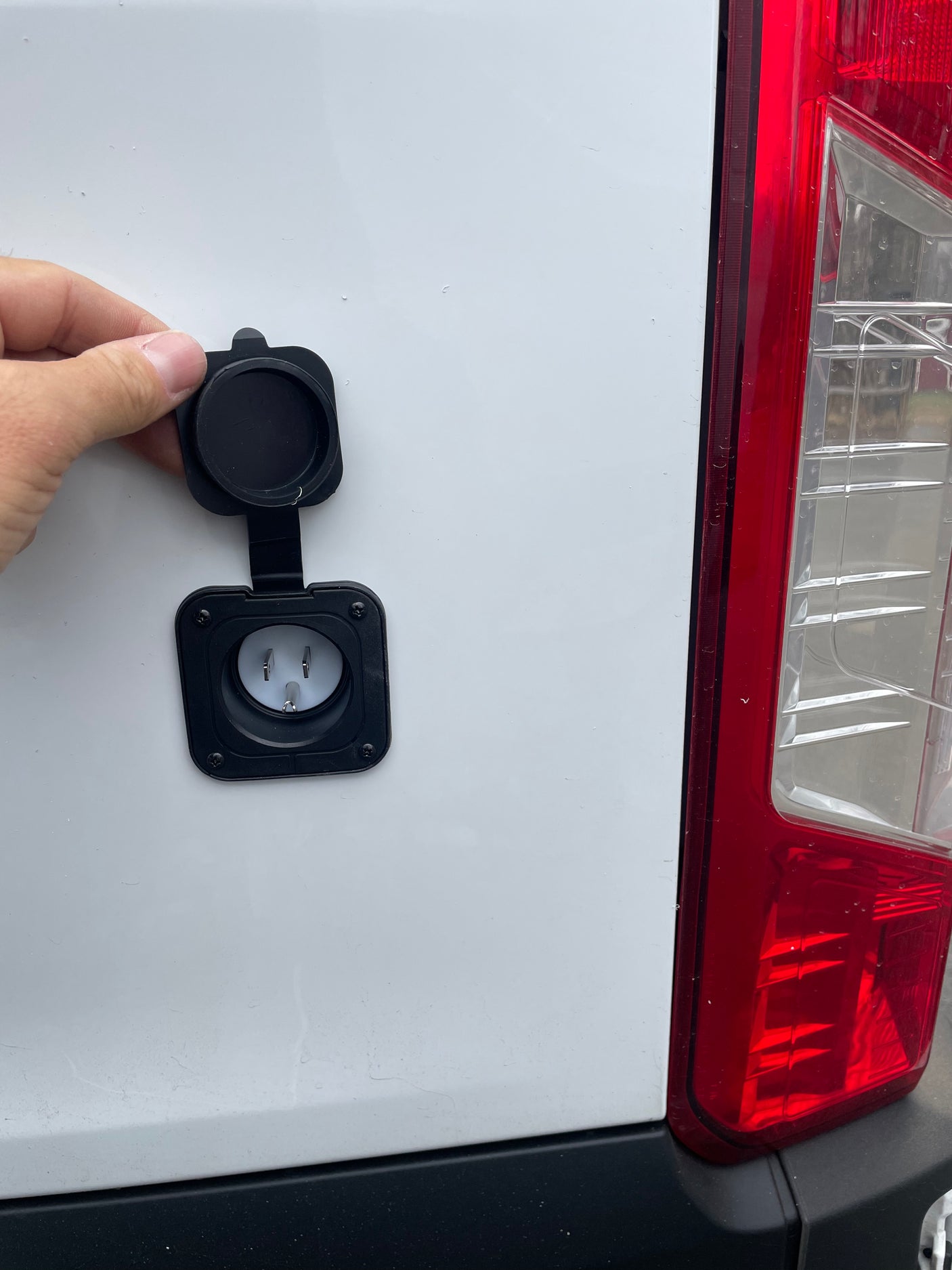Accessing shore power: An RV rental's exterior electrical inlet for charging purposes.