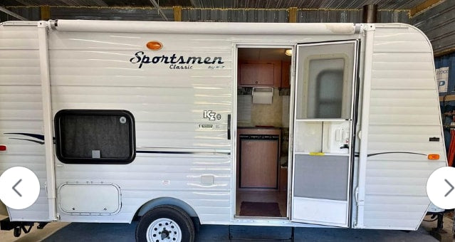 White Sportsmen Classic RV rental with its side door open