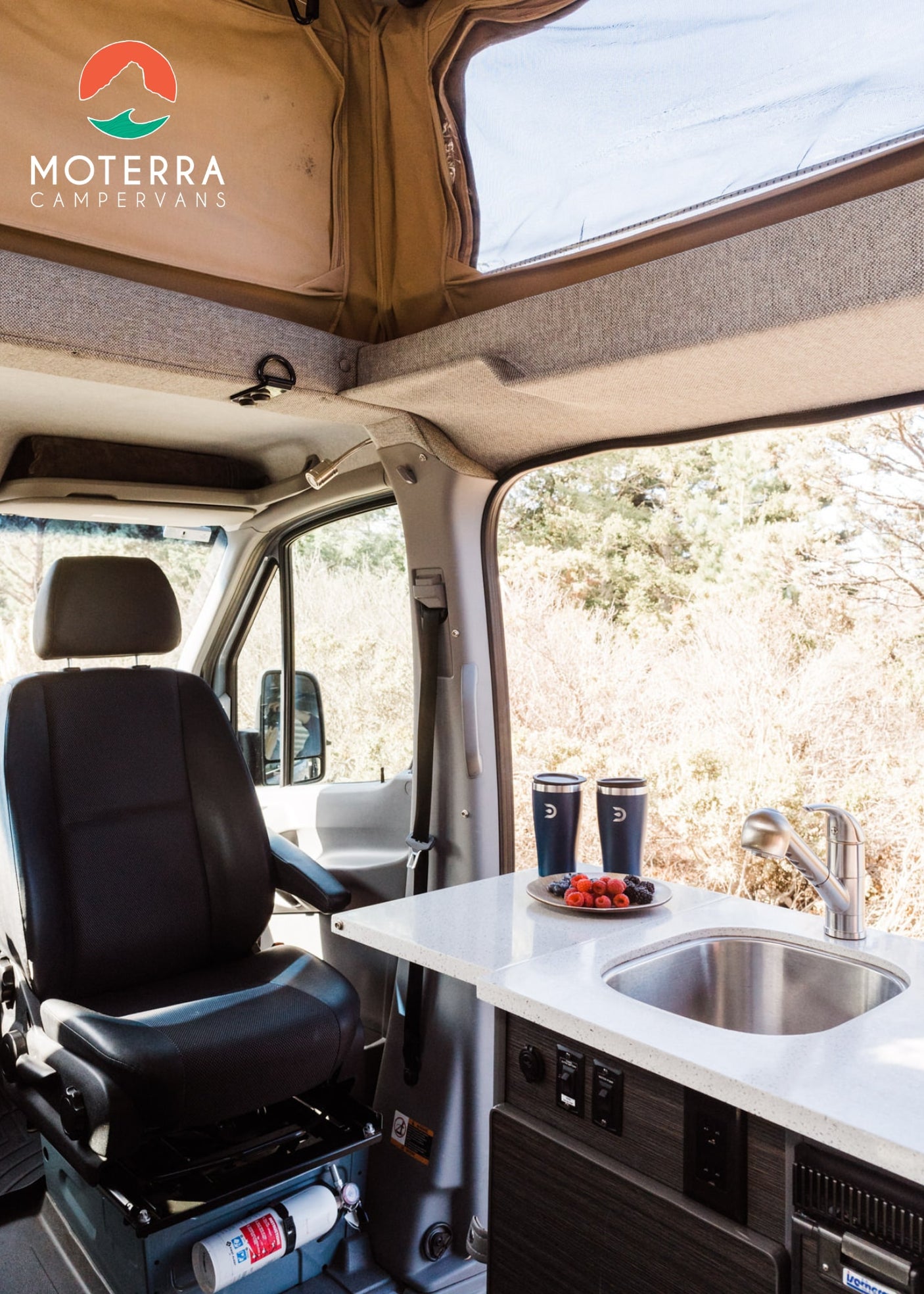 and scenic views outside.|A person cooks outside a grey RV rental campervan